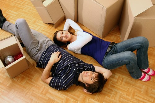 Professional movers carrying furniture down stairs in a central London flat